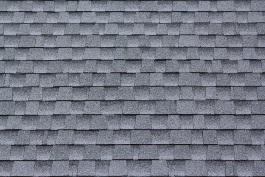 Close-up view of gray asphalt roof shingles arranged in a uniform pattern.